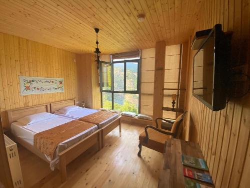 sypialnia z łóżkiem i dużym oknem w obiekcie Chateau Chao w mieście Khulo