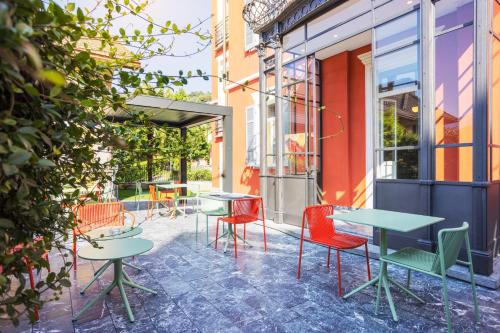 een patio met tafels en stoelen buiten een gebouw bij Villa Rossella in Locarno