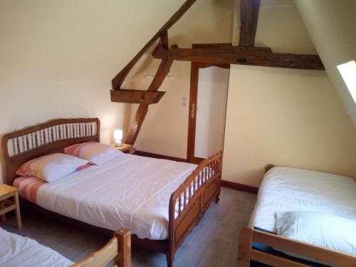 GITE LA GRANDE AVALOUX في Artannes-sur-Indre: سريرين توأم في غرفة مع عوارض خشبية