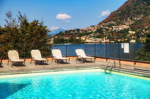 a swimming pool with chairs and a mountain at Florissa - by MyHomeInComo in Blevio