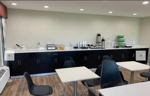 ein Zimmer mit Tischen und Stühlen sowie einer Küche in der Unterkunft Days Inn by Wyndham Bellville Mansfield in Bellville
