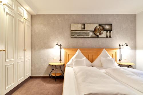 1 dormitorio con 1 cama con sábanas blancas en Zur Alten Gärtnerei, en Westerland
