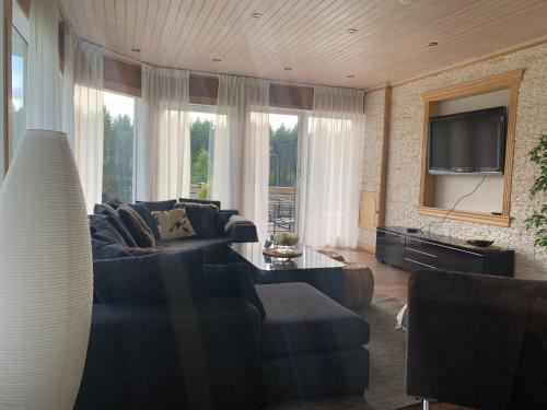 ein Wohnzimmer mit einem Sofa und einem TV in der Unterkunft Paradise-Silvergruvan in Hällefors