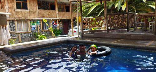 two girls swimming in a pool with an inner tube at Ricky's House in Baños