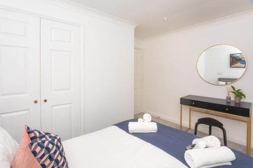 a bedroom with a bed and a desk and a mirror at Crescent Mews in Bath