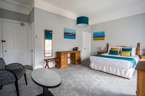 a bedroom with a bed and a table and chairs at The Juniper Rooms in Montrose