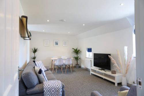 uma sala de estar com um sofá e uma televisão em Shorebreak - Bracklesham Bay Apartment em Chichester