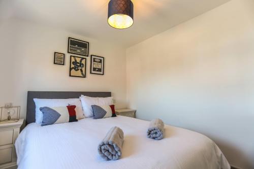 a bedroom with a white bed with two pillows at Shorebreak - Bracklesham Bay Apartment in Chichester