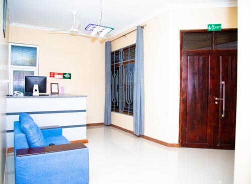 a living room with a blue chair and a door at Joleen Safari Park in Dar es Salaam