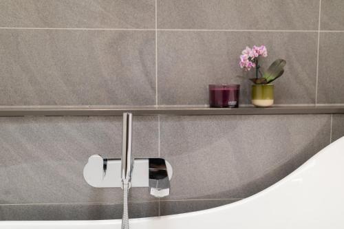 a bathroom with a sink and a shelf with flowers at Crescent Mews in Bath