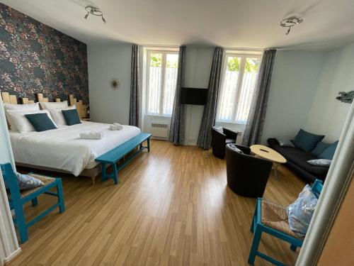 a bedroom with a large bed and a couch at Les trois cèdres in Saint-ouen-dʼAunis