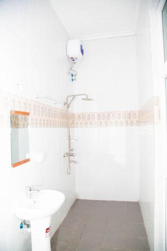 a white bathroom with a sink and a toilet at Joleen Safari Park in Dar es Salaam