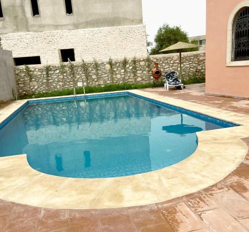 - une piscine d'eau bleue dans la cour dans l'établissement Riad Aïcha Addi - Poolside - Traditional Moroccan, à Essaouira