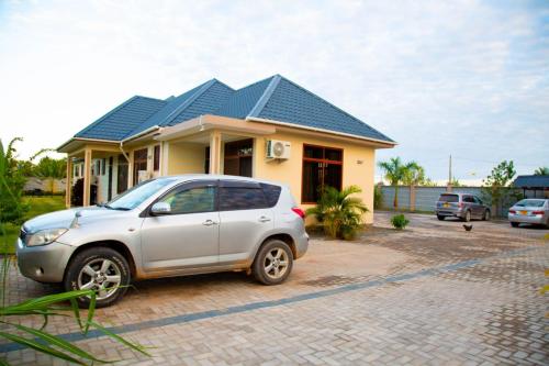 a small car parked in front of a house at Joleen Safari Park in Dar es Salaam