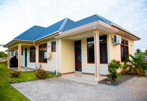 a small house with a blue roof at Joleen Safari Park in Dar es Salaam
