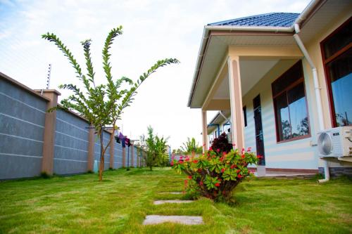 a house with a yard with some flowers in front of it at Joleen Safari Park in Dar es Salaam