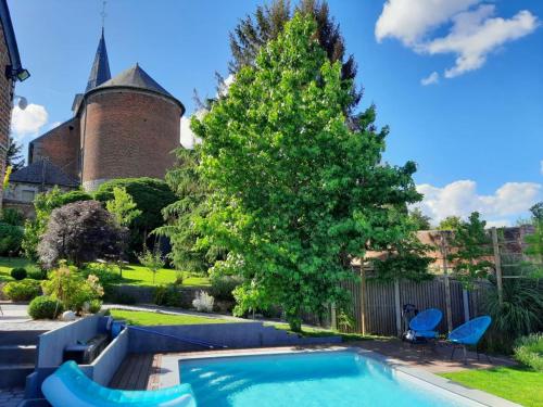 een zwembad in een tuin met een kasteel bij Au pousseux d'église 