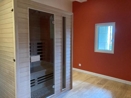 a glass shower in a room with a window at Le Manoir des Sables - Chambre familiale grand confort in Berthegon