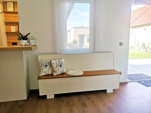 a bench in a room with a window and pillows at Haus Weiss bei Julia in St. Andrä am Zicksee