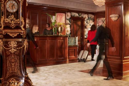 a group of people walking through a room with a clock at Hotel Estheréa in Amsterdam
