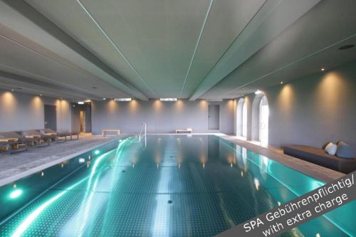 a large swimming pool in a building with a pool at Hotel Stadt Breisach in Breisach am Rhein