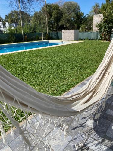 a hammock sitting in front of a pool at Bitcoin s House Quinta Familiar 1000 m2 Piscina in Santa Ana