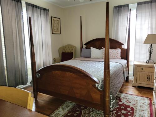 a bedroom with a wooden bed with a four poster bed sidx sidx sidx at Brick House Retreat in Hamlet
