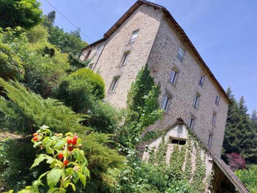 a large brick building on the side of a hill at SAGE Studio in Treignac