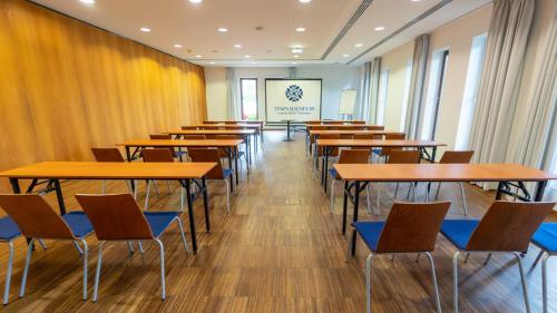 a row of tables and chairs in a room at Tisza Balneum Hotel in Tiszafüred