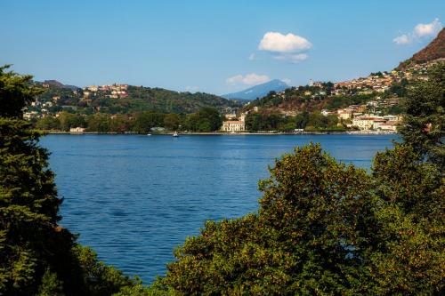 a view of a large body of water with trees at Florissa - by MyHomeInComo in Blevio