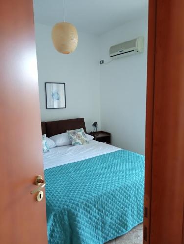 1 dormitorio con 1 cama con manta azul en Carmen Suite, en Cefalú