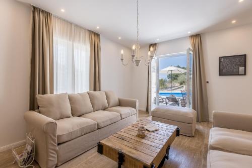 a living room with a couch and a table at Villa La Residenza - Heated pool in Podstrana