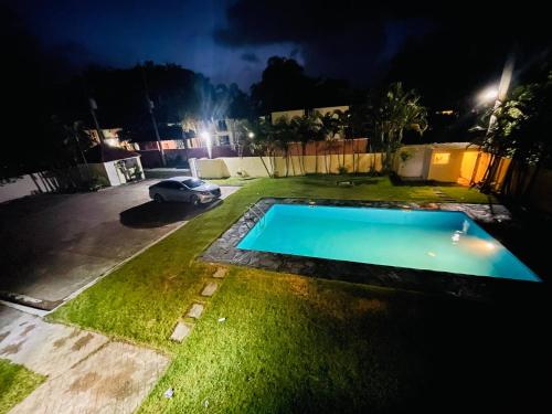 a swimming pool in a yard at night at Lovely 2 Bedroom Condo With Pool And Hot Water in Cabarete