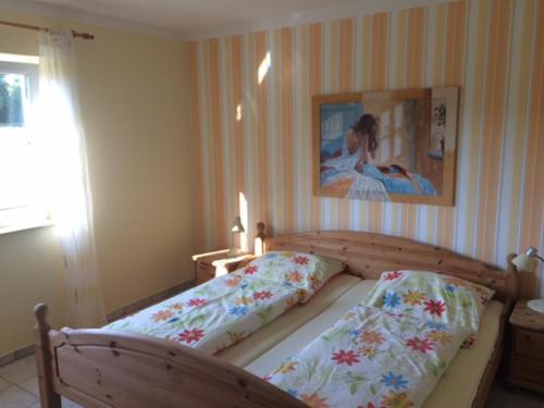 a bedroom with a bed and a painting on the wall at Urlaub auf dem Bauernhof Marx in Kelberg