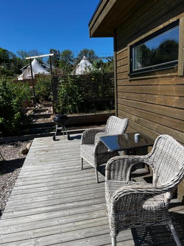 two chairs and a table on a wooden deck at Fantastisk Vätterutsikt mellan Habo och Bankeryd. in Habo
