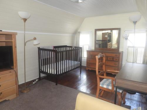 a room with two cribs and a table and a mirror at Brick House Retreat in Rockingham