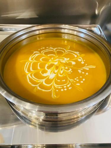 a bowl of yellow soup with a flower painted on it at Rockmila Hotel in Phu Quoc