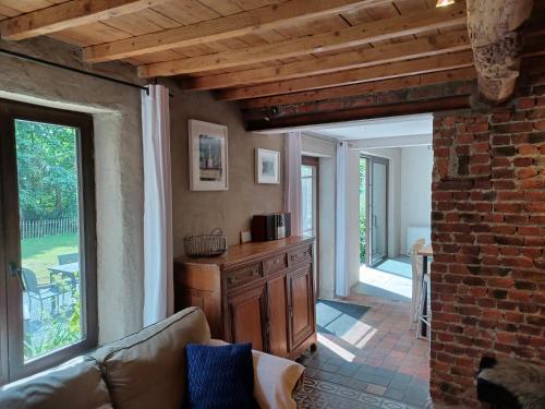 a living room with a couch and a brick wall at La Ferme du Couchant in Beauraing