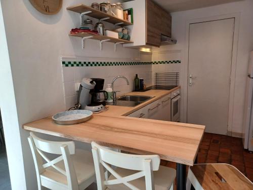 a kitchen with a wooden counter and two stools at La Ferme du Couchant in Beauraing
