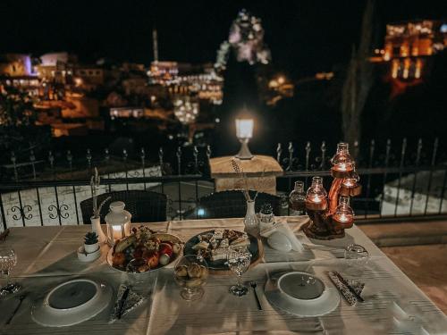 a table with a plate of food on it with a view at Iris Cave Cappadocia in Ortahisar