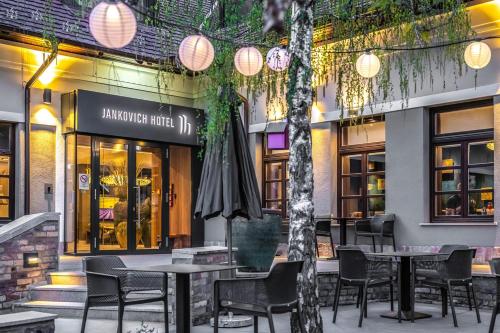 a restaurant with tables and chairs and an umbrella at Jankovich Hotel in Rácalmás