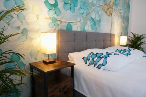 a bedroom with a bed and a table with a lamp at Mein Apartment Flowers mit Kamin, bis 10 Personen in Frankenthal