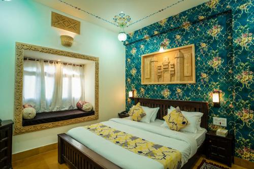 a bedroom with two beds and a mirror at Tripli Hotels Prithvi Palace in Jaisalmer