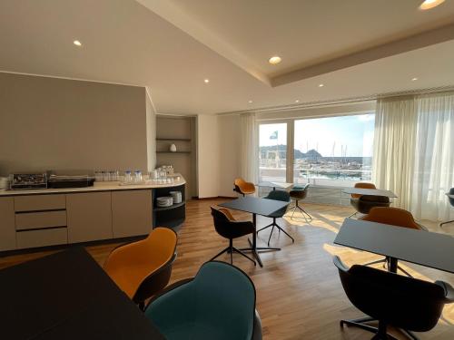 a room with tables and chairs and a large window at Sestante Marina Motel in Capo dʼOrlando