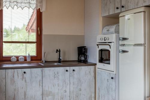 a kitchen with a white refrigerator and a sink at Dom z Widokiem Mucharz 405 in Mucharz