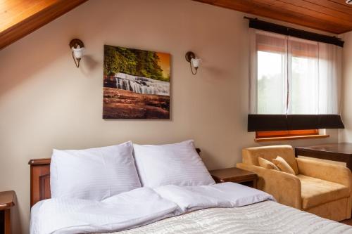 a bedroom with a bed and a chair at Dom z Widokiem Mucharz 405 in Mucharz