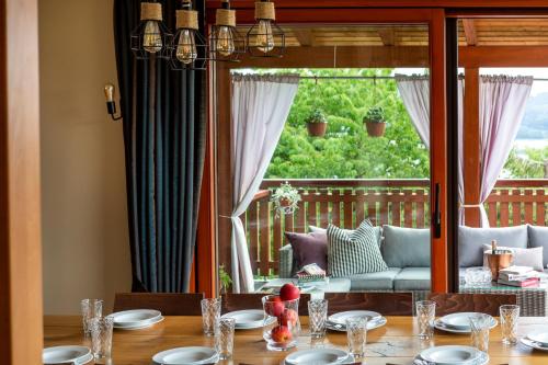 a dining room with a table and a large window at Dom z Widokiem Mucharz 405 in Mucharz