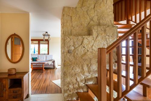 a stone wall in a living room with a staircase at Dom z Widokiem Mucharz 405 in Mucharz