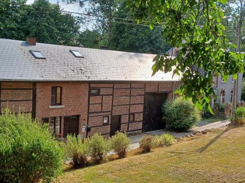 an old brick building with a garage at La Ferme du Couchant in Beauraing