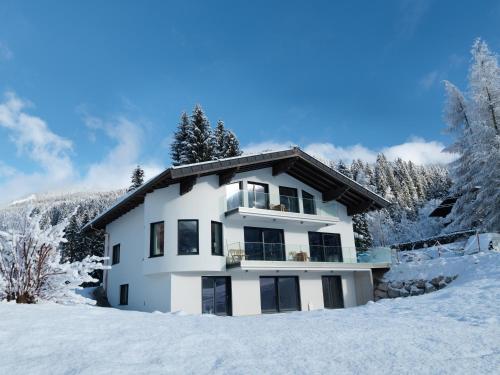 a white house in the snow at Apartmenthaus Mountainvista in Kleinarl